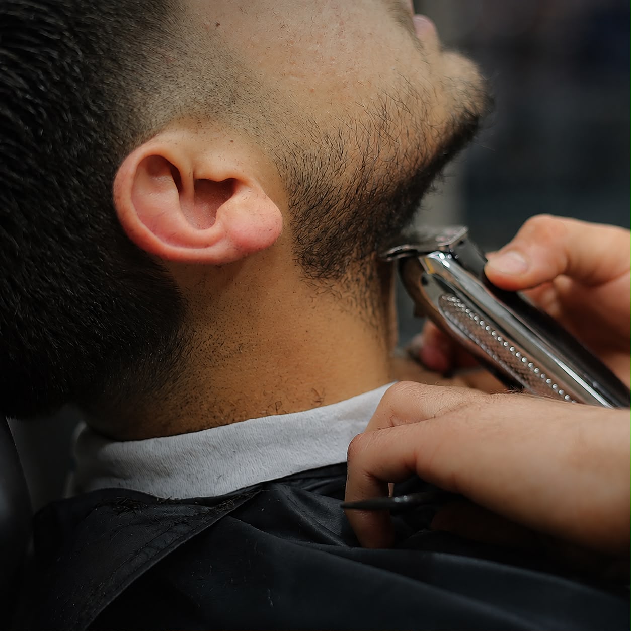 Close-up detail of a beard line-up with clippers
